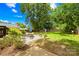 Serene backyard with a patio seating area, lush green grass, mature trees, and a wooden privacy fence at 2919 Dunaire Dr, Charlotte, NC 28205