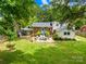 Spacious backyard with a patio, lush lawn, and mature trees, perfect for outdoor entertaining and relaxation at 2919 Dunaire Dr, Charlotte, NC 28205