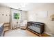 Bright Bedroom with a modern crib, glider, hardwood floors, and natural light perfect for a new baby at 2919 Dunaire Dr, Charlotte, NC 28205