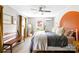 Sunlit bedroom with a ceiling fan, comfortable bed, and an orange painted accent wall at 2919 Dunaire Dr, Charlotte, NC 28205
