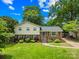 Charming two-story home featuring a well-manicured lawn, brick accents, and lush landscaping under a sunny sky at 2919 Dunaire Dr, Charlotte, NC 28205