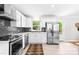 Bright kitchen features stainless appliances, white cabinets, gray tile backsplash, and tile flooring at 2919 Dunaire Dr, Charlotte, NC 28205