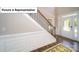 Elegant foyer featuring wainscoting, hardwood floors, an ornate staircase, and a decorative glass front door at 4266 Sylvan Pond Ct, Denver, NC 28037