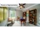 Bright home office with desk, chair, wooden shelves, and a window overlooking the yard at 4266 Sylvan Pond Ct, Denver, NC 28037
