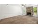 Bright living room features a stone fireplace, ceiling fan, neutral carpeting and a door that leads to the backyard at 4333 Dunwoody Dr, Charlotte, NC 28215