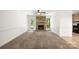 Bright living room features a stone fireplace, ceiling fan, neutral carpeting and a door that leads to the backyard at 4333 Dunwoody Dr, Charlotte, NC 28215