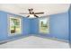 Bedroom with blue walls, white carpet, and a ceiling fan with views from two windows at 439 Neisler Rd, Concord, NC 28025