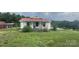 Quaint single-story home with a red roof and covered front porch surrounded by a large yard at 439 Neisler Rd, Concord, NC 28025