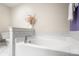 Bright bathroom with a large soaking tub and neutral-tiled walls at 4442 Coventry Row Ct, Charlotte, NC 28270
