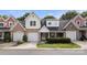 Traditional-style home featuring brick accents, multiple garage doors, and a manicured lawn at 4442 Coventry Row Ct, Charlotte, NC 28270