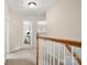 Well-lit upstairs hallway with a view of a room with large windows at 4442 Coventry Row Ct, Charlotte, NC 28270