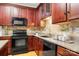 This kitchen features cherry cabinets, granite countertops, and black appliances, offering a blend of style and functionality at 4442 Coventry Row Ct, Charlotte, NC 28270
