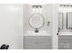This renovated bathroom features a sink with a gray cabinet, mirror, and updated lighting at 4601 Coronado Dr, Charlotte, NC 28212