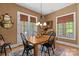 Cozy dining room with rustic wood table, chandelier, neutral walls, and natural light from backyard view windows at 5112 Mill Race Ln, Lancaster, SC 29720
