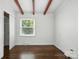 Bedroom featuring hardwood floors, closet, exposed beams, and natural light at 5229 Milford Rd, Charlotte, NC 28210