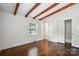 Bedroom featuring hardwood floors, closet, exposed beams, and natural light at 5229 Milford Rd, Charlotte, NC 28210