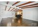 Spacious room with wood floors, beams, and kitchen view at 5229 Milford Rd, Charlotte, NC 28210