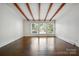 Spacious living room with hardwood floors, wood beams, and large windows at 5229 Milford Rd, Charlotte, NC 28210