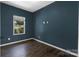 Cozy bedroom painted navy blue and featuring hardwood floors and a sunlit window at 556 Big Lick Rd, Stanfield, NC 28163