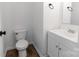 Clean half bathroom with white vanity, a modern toilet, and neutral-colored walls at 556 Big Lick Rd, Stanfield, NC 28163