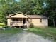 Charming single story home with a covered front porch and gravel driveway surrounded by mature trees at 5881 Robinhood Rd, Fort Lawn, SC 29714