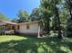View of the side of a single-story house with yellow siding, set amidst lush greenery and a clear blue sky at 5881 Robinhood Rd, Fort Lawn, SC 29714