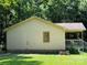 Side view of a light yellow home with a brick foundation and a covered porch, showcasing its simple design at 5881 Robinhood Rd, Fort Lawn, SC 29714