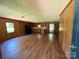 An open floor plan showing a living room with wood paneled walls, hardwood floors and view of the kitchen at 5881 Robinhood Rd, Fort Lawn, SC 29714