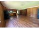 An open-concept living area features hardwood floors, wood paneled walls, and a view to the kitchen with modern appliances at 5881 Robinhood Rd, Fort Lawn, SC 29714