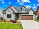 Beautifully landscaped, two-story home featuring a stone facade, brick accents, and a two-car garage at 6107 Gold Springs Way, Denver, NC 28037