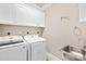 Laundry room with white washer and dryer, sink, storage cabinets and shelving at 6107 Gold Springs Way, Denver, NC 28037