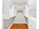 Walk-in closet includes custom shelving and rods for ample storage with hardwood floors at 6107 Gold Springs Way, Denver, NC 28037