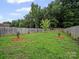 Landscaped backyard with mulch and trees surrounded by a wood fence at 6803 Ware Rd, Charlotte, NC 28212