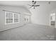 Bright bedroom features a ceiling fan, two windows, and neutral carpeting at 6803 Ware Rd, Charlotte, NC 28212