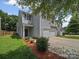 View of home with a two car garage, landscaping, and small front yard at 6803 Ware Rd, Charlotte, NC 28212