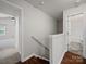 Upstairs hallway leading to bedrooms and bathroom with wood flooring at 6803 Ware Rd, Charlotte, NC 28212