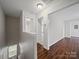 Bright hallway featuring hardwood floors and white trim throughout at 6803 Ware Rd, Charlotte, NC 28212