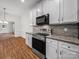 Modern kitchen with stainless steel appliances, stone backsplash and white cabinets at 6803 Ware Rd, Charlotte, NC 28212