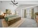 Spacious main bedroom featuring a ceiling fan, two windows, and a plush bed at 6803 Ware Rd, Charlotte, NC 28212