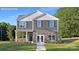 Two-story home featuring stone accents, gray siding, dark shutters, manicured landscaping and walkway to covered front porch at 780 14Th Avenue Ne Ct, Hickory, NC 28601