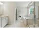 Bright, clean bathroom featuring a double vanity, glass shower, and soaking tub with natural light at 812 Dogwood Creek Ln, Indian Trail, NC 28079