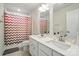 Modern bathroom featuring a double vanity, tiled floors, a shower with a patterned curtain and a separate toilet at 812 Dogwood Creek Ln, Indian Trail, NC 28079