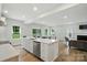Modern kitchen with stainless steel appliances, white cabinets, a kitchen island and open views of the living room at 812 Dogwood Creek Ln, Indian Trail, NC 28079