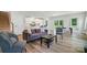 Bright living room featuring modern furnishings, wood floors, and an open floor plan to the kitchen and dining area at 812 Dogwood Creek Ln, Indian Trail, NC 28079