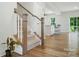 Elegant staircase leading to an open-concept living space with hardwood floors and natural light at 812 Dogwood Creek Ln, Indian Trail, NC 28079
