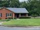 Charming brick home featuring a lush green lawn and mature trees in a peaceful neighborhood at 8421 Coulwood Oak Ln, Charlotte, NC 28214
