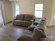 Inviting living room featuring updated floors, ample natural light, and comfortable seating at 8421 Coulwood Oak Ln, Charlotte, NC 28214