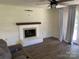 Bright living room with a brick fireplace, wood mantle, and access to the backyard at 8421 Coulwood Oak Ln, Charlotte, NC 28214