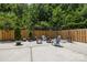 A concrete patio is landscaped with a fire pit, lounge chairs, and a wooden privacy fence at 849 Savile Ln, Fort Mill, SC 29715