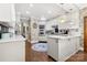 Modern white kitchen with stainless steel appliances, stone accent wall, and hardwood floors at 849 Savile Ln, Fort Mill, SC 29715